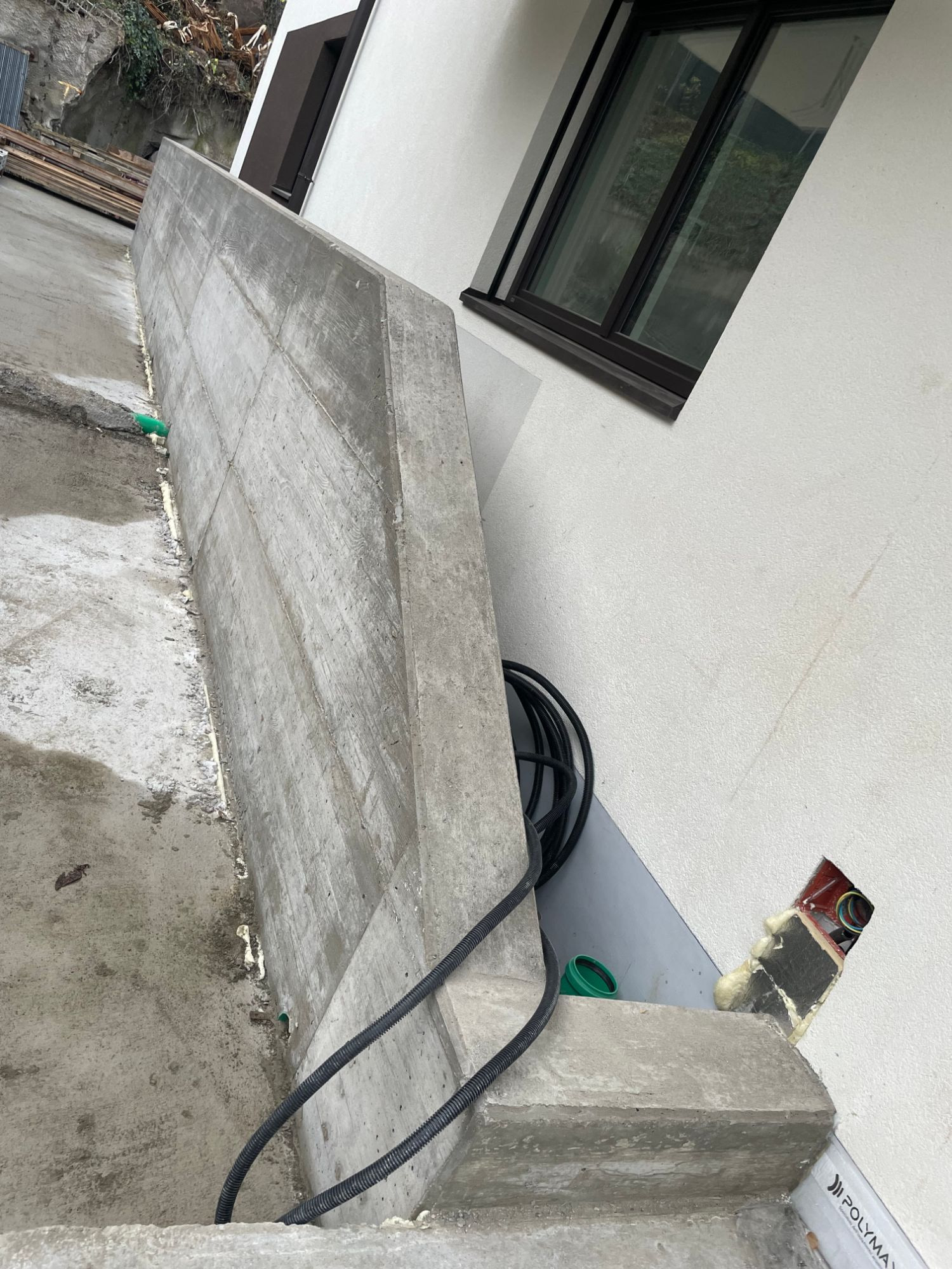 Testata del muro accanto alla facciata con i tubi corrugati per gli impianti