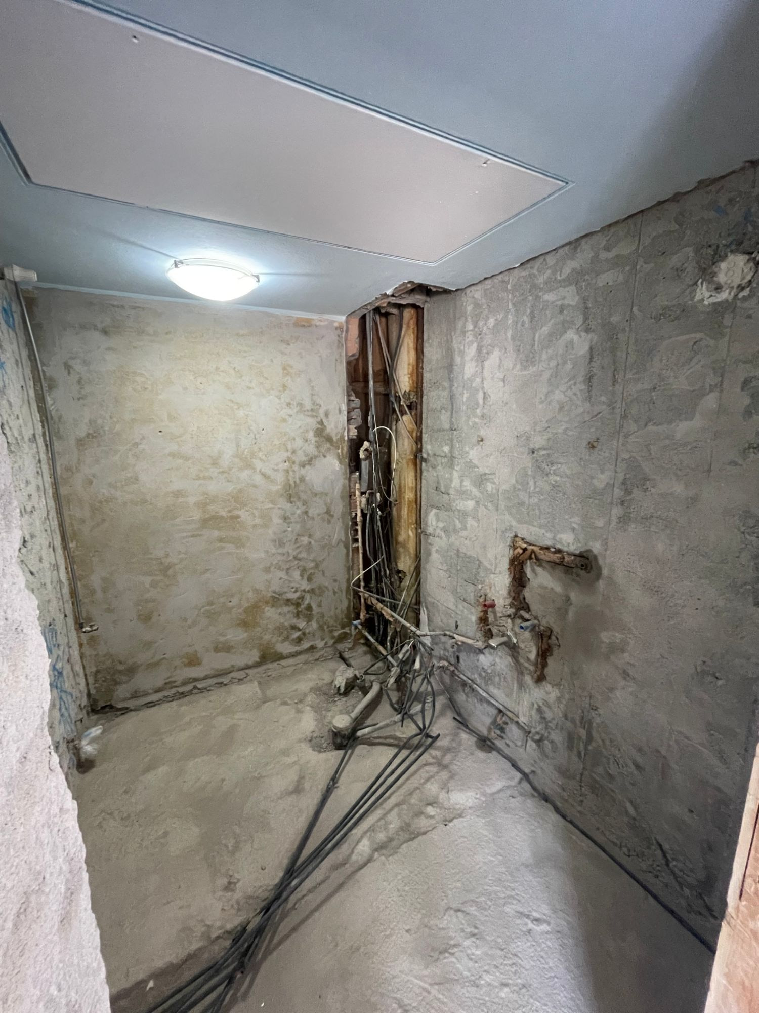 Bagno demolito con i vecchi attacchi a parete e i cavi a pavimento