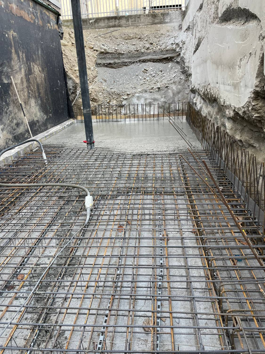 Getto della platea con la pompa per calcestruzzo e il vibratore